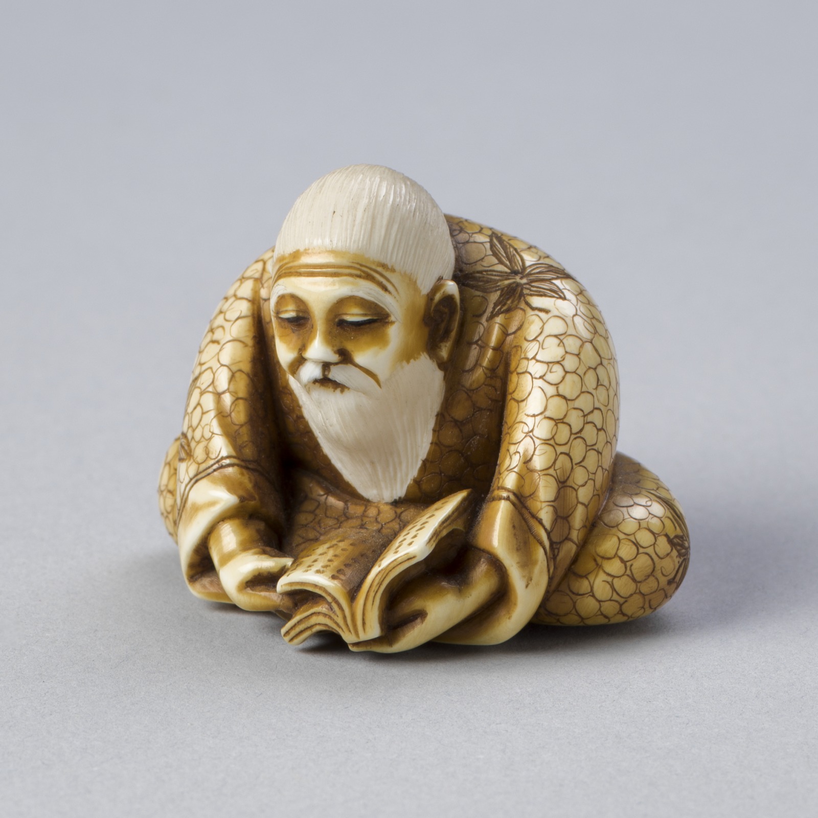 Netsuke Depicting an Old Man Reading a Book